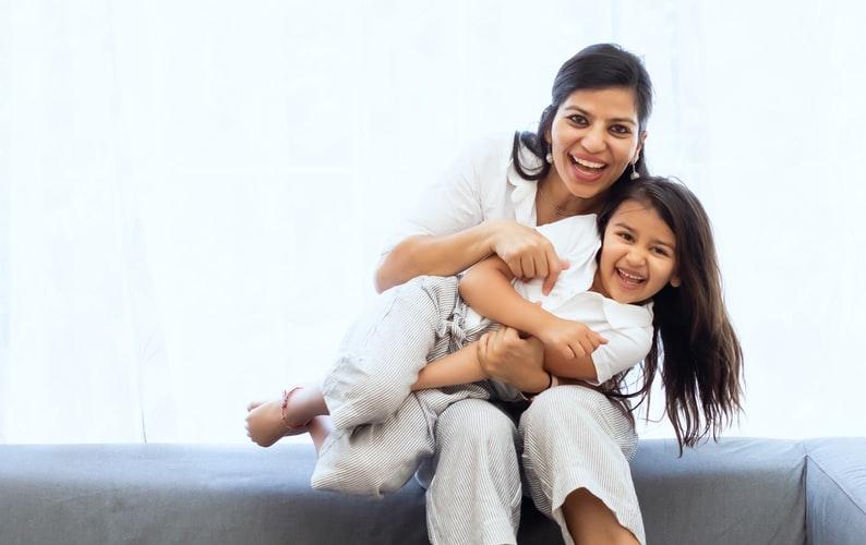 A mother and daughter smiling together after a visit to Advait Dental Clinic